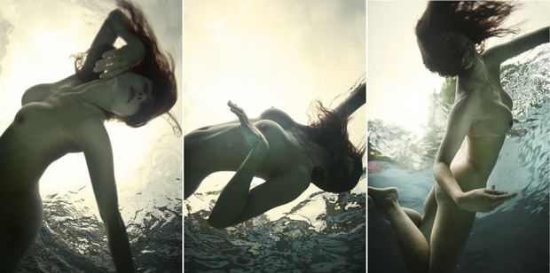 Doing naked acrobatics underwater. She hides her identitiy with her hair.