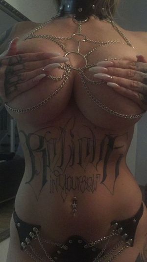 Tattooed bimbo in a chain harness