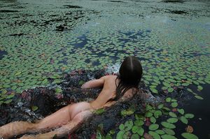 Beautiful Teen Swims in the Lake with the Lily Pads