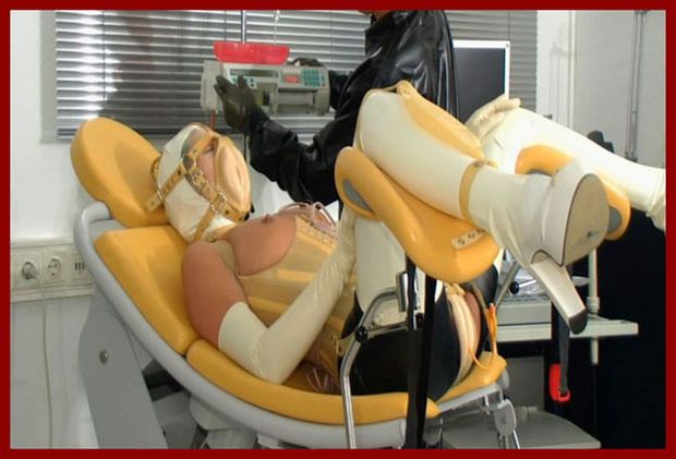 woman with rubber vagina on her face sits in chair
