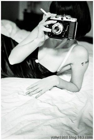 smoking chick laying on bed and take a shoot with analog camera