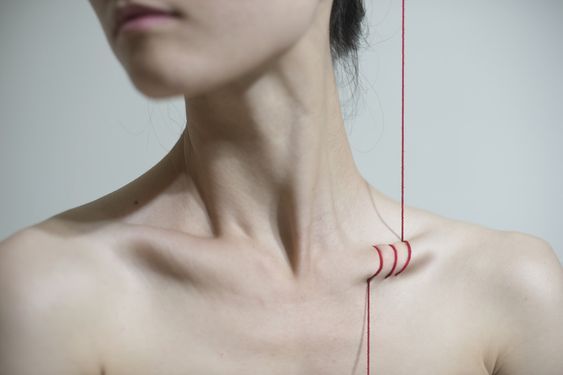 Red String through collarbone