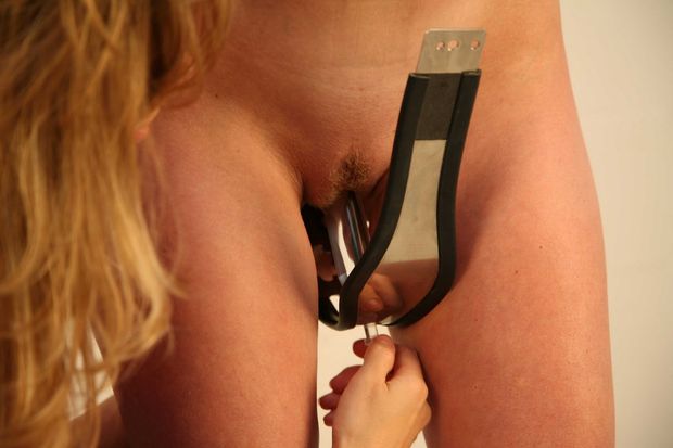 inserting metal dildo on chastity belt