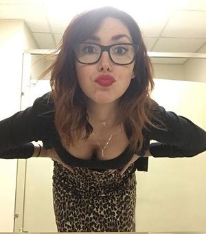 Redhead in glasses letting you look down her shirt