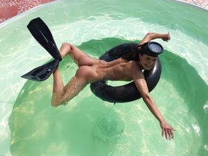Nude in the pool with snorkeling equipment.