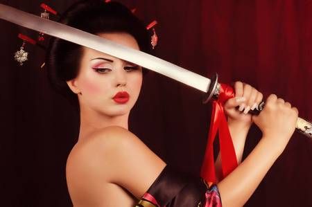 Schöne Geisha im Kimono mit Samurai-Schwert Standard-Bild - 25613054