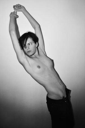 b&w tomboy leans against wall