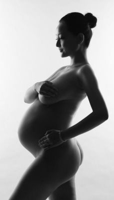 Silhouette of nude, pregnant Asian
