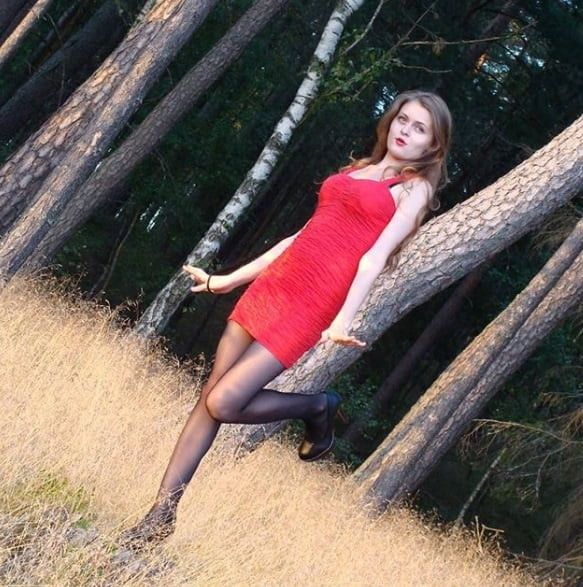 Nice brunette babe in red mini dress posing outdoors