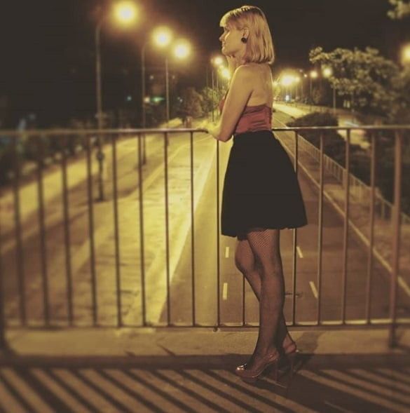 Nice insta blonde babe posing outdoors in sexy red top, loose miniskirt, fishnets and high heels