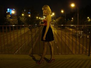 Hot blonde chick posing outdoors in fishnets and red corset