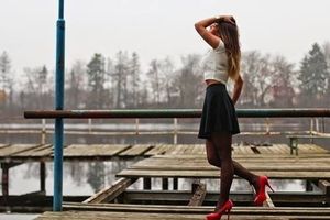 Insta babe posing oudoors in red heels and black flared miniskirt