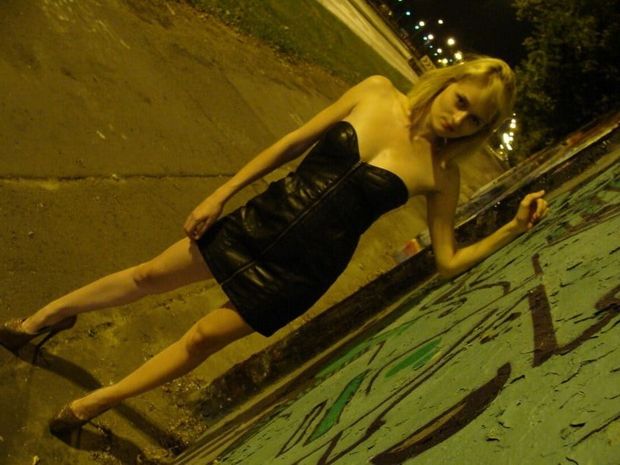 Cute and hot insta chick posing outdoors in leather tight black sexy mini dress