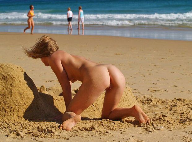 Building a sand castle nude.