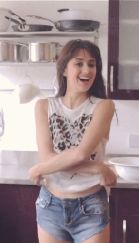 gif - cute brunette in jean shorts stripping off her shirt showing her tits