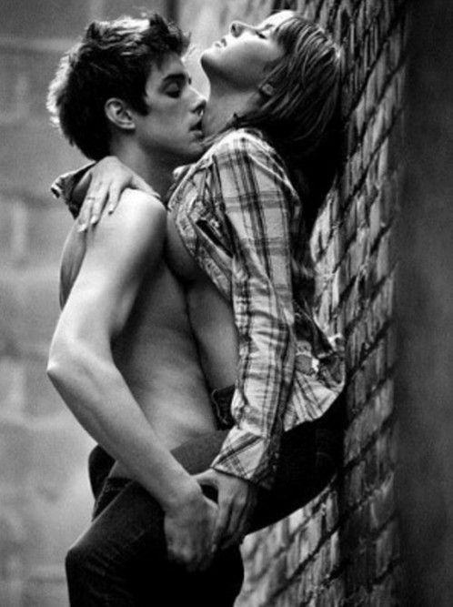 Couple kissing against a wall