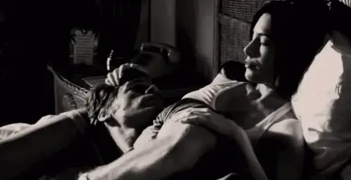 She strokes his head as he lies across her belly