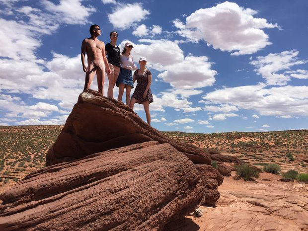 nude male outdoors posing with three babes