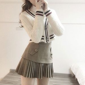 White sweater and grey skirt