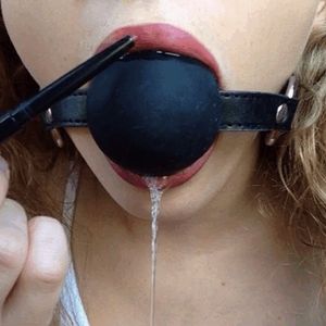 cute painting her lips while being gagged with a big gagball
