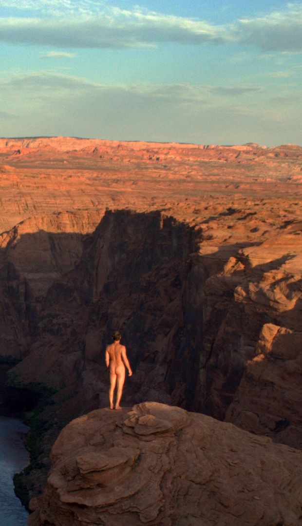 nude male outdoors displaying ass in front of canyon