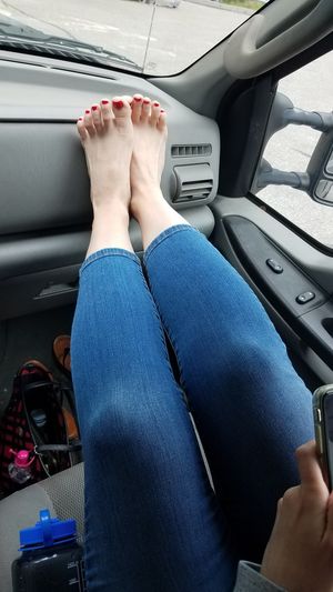 Feet with red toes up on dash