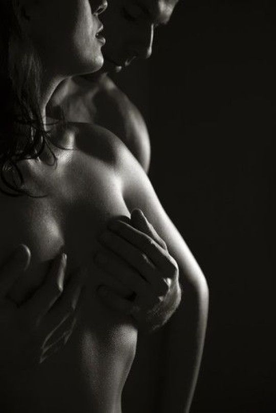 Sensuous hug, holding her breasts