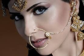 Large nose ring with chain, Indian bride is being dressed.