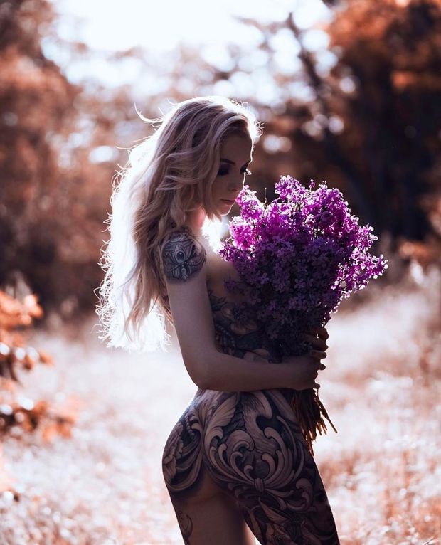 Tattooed blonde with flowers on a hot summer day