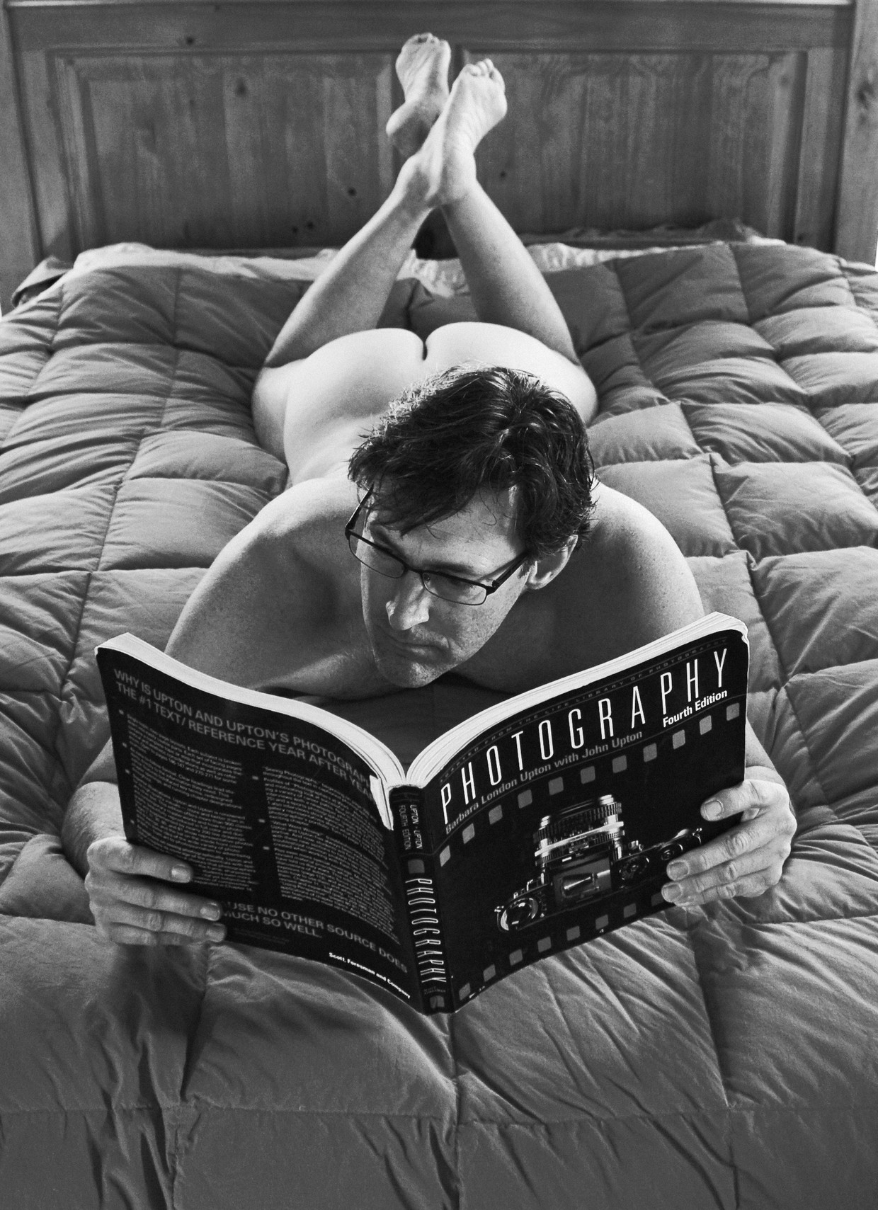nude male displaying ass while reading on bed