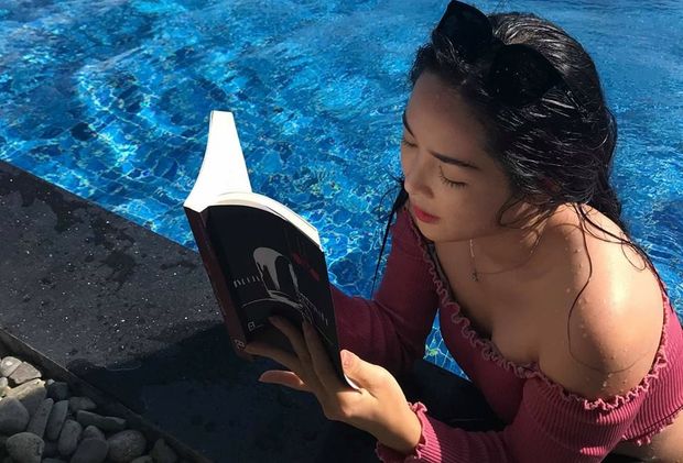 Beautiful Vietnamese woman reading a book