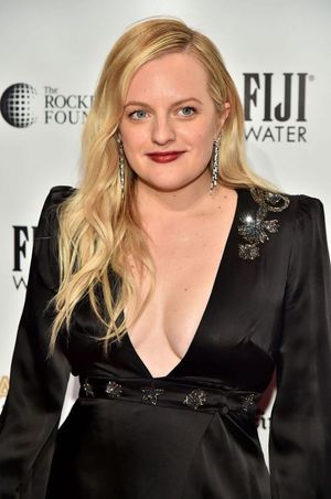Elisabeth Moss braless boobs showing nice cleavage in a low cut black dress photographed by paparazzi.