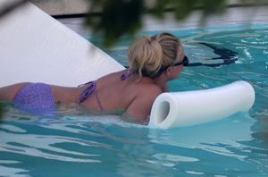 Britney Spears in a sexy bikini showing her ass and nice cleavage with her big boobs photographed by the pool by paparazzi.