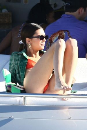 Kendall Jenner in a sexy thong bikini on a yacht with friends tanning showing her perfect model body seen by paparazzi.