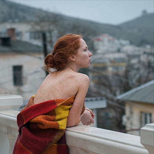 on balcony, wrapped in blanket