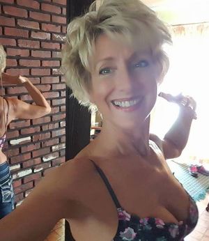 Mature Blonde Smiles and Bares Cleavage