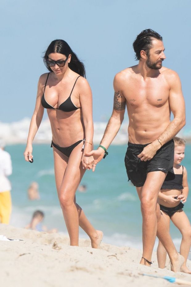 Giorgia Gabriele in a sexy little black bikini showing off her perfect model body and nice cleavage seen by paparazzi at the beach in Miami.