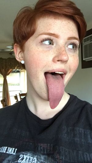 Cute redhead sticks out her huge tongue