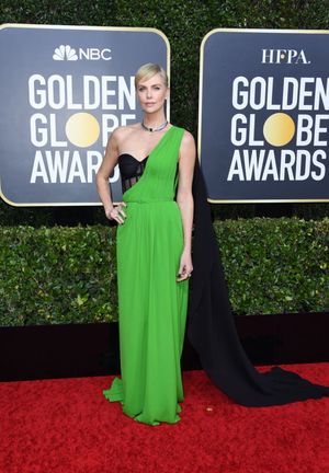 Charlize Theron in a sexy green and black dress photographed arriving at the Golden Globe Awards.