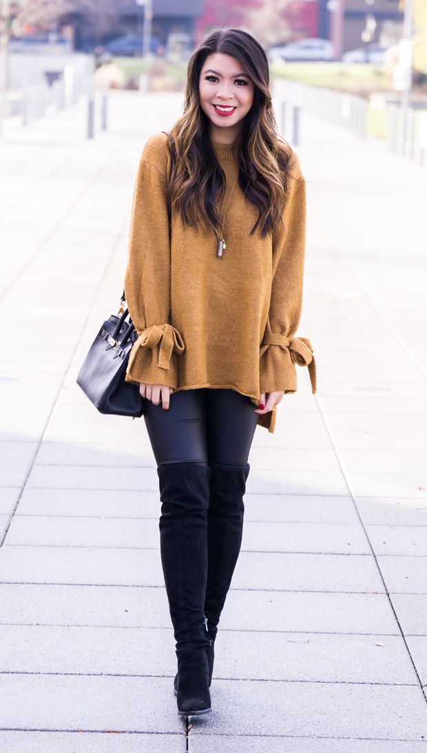 Pretty asian in an orange sweater, black leggings and boots
