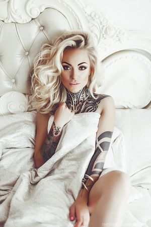 White bed with tattooed blonde.