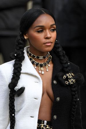 Janelle Monae braless boobs showing nice cleavage with her big tits in an open jacket top seen by paparazzi in Paris for fashion week.