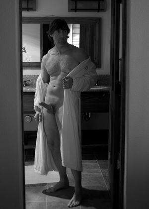 semi nude male displaying swollen erection wearing robe