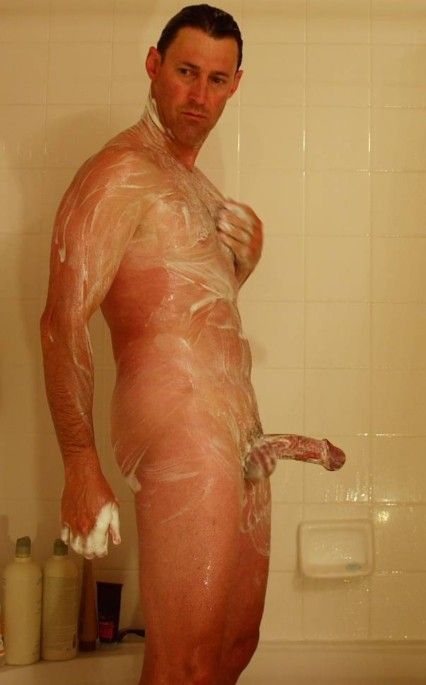 nude male in shower soaping semi-erect cock and balls