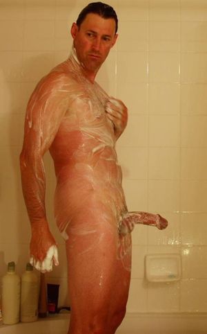 nude male in shower soaping semi-erect cock and balls