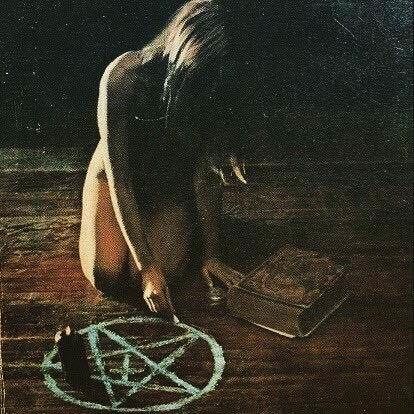 Nude sorceress drawing pentagram
