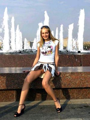 A cute teen babe in public without pants posing