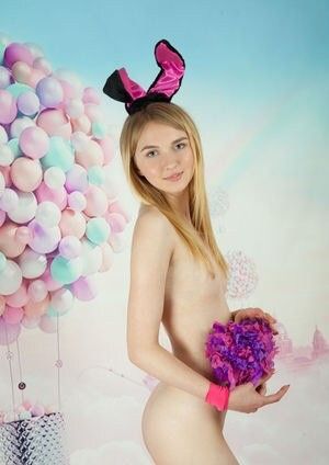 Cute blonde standing, holding a pom pom