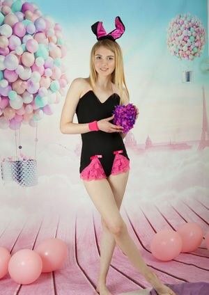 Cute blonde standing with her legs crossed