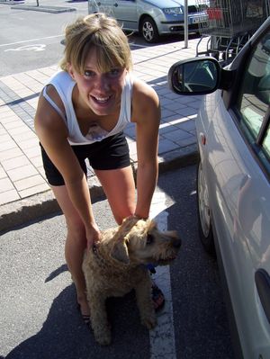Woman shows downblouse while tending to dog